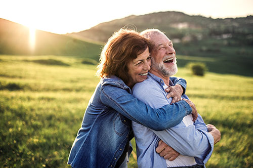 -view-of-senior-couple-hugging-outside-in-spring-nature-at-sunset. (1)