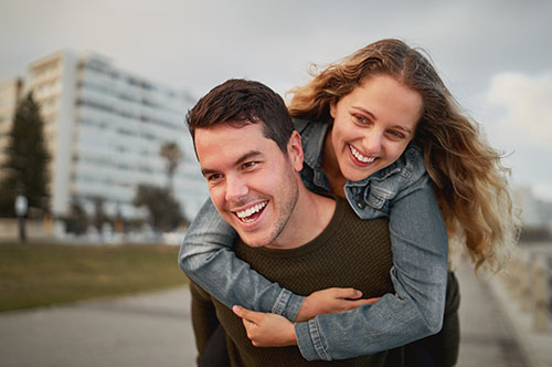 500x332_0016_Cheerful-young-man-carrying-a-woman-on-his-back-outdoors-in-the-city-street-laughing-and-having-fun